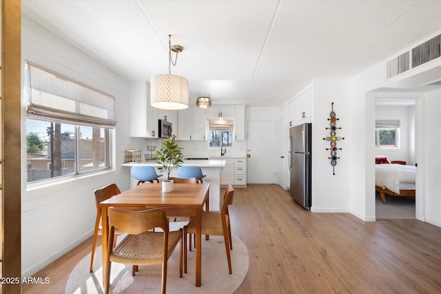 3737 E Turney Ave Unit 206, Phoenix, AZ 85018 - dining space with light wood-style floors and baseboards