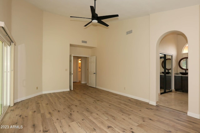 unfurnished room featuring ceiling fan, visible vents, high vaulted ceiling, and wood finished floors