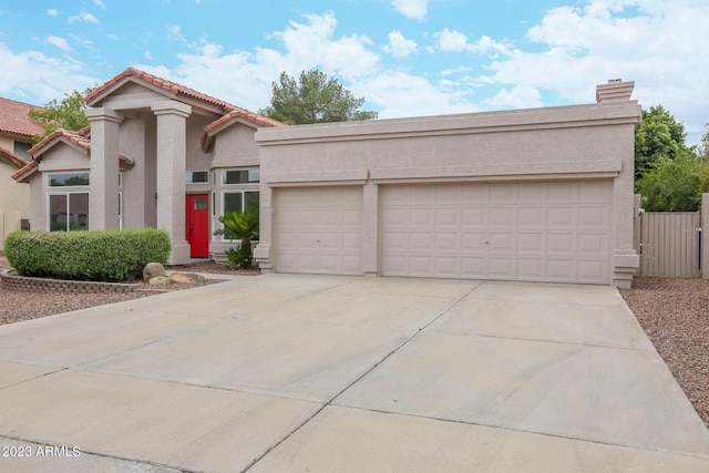 mediterranean / spanish-style house featuring stucco siding, a tiled roof, concrete driveway, and an attached garage