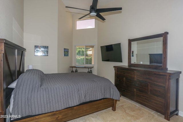 bedroom with a high ceiling and ceiling fan