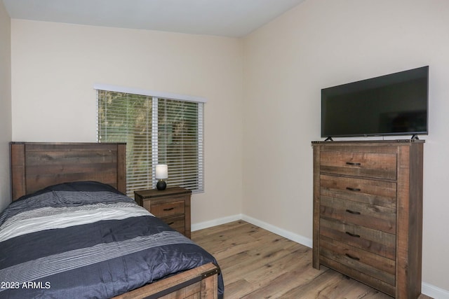 bedroom featuring baseboards and wood finished floors