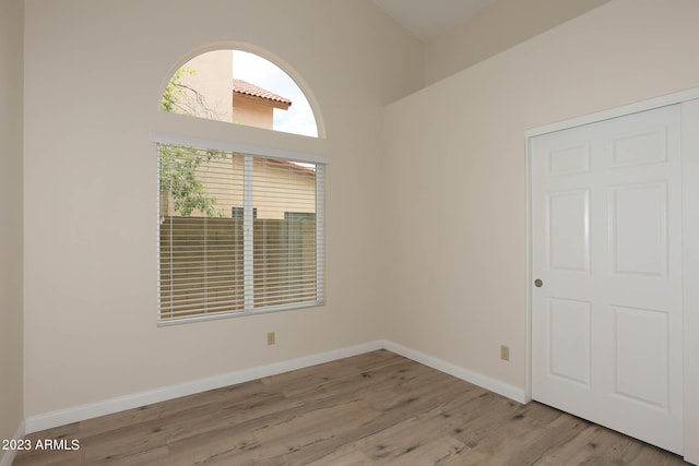 spare room featuring baseboards and light wood-type flooring