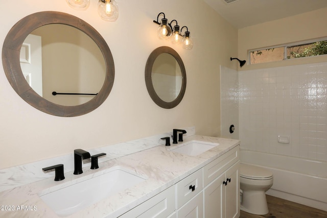 bathroom featuring double vanity, toilet, wood finished floors, and a sink