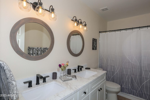 full bathroom with a sink, visible vents, toilet, and double vanity