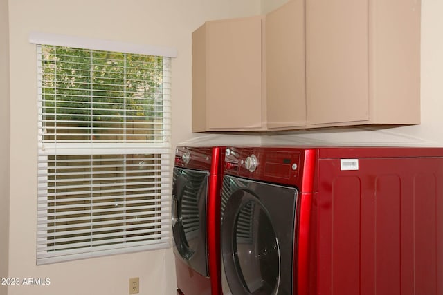 clothes washing area featuring washer and dryer and cabinet space