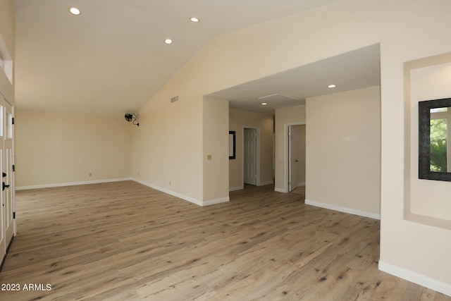 empty room featuring visible vents, recessed lighting, light wood-style floors, baseboards, and vaulted ceiling