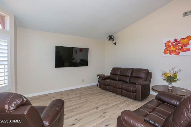 living room featuring visible vents, baseboards, wood finished floors, and vaulted ceiling