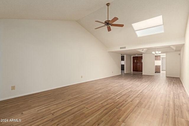 unfurnished living room featuring hardwood / wood-style floors, ceiling fan with notable chandelier, and high vaulted ceiling