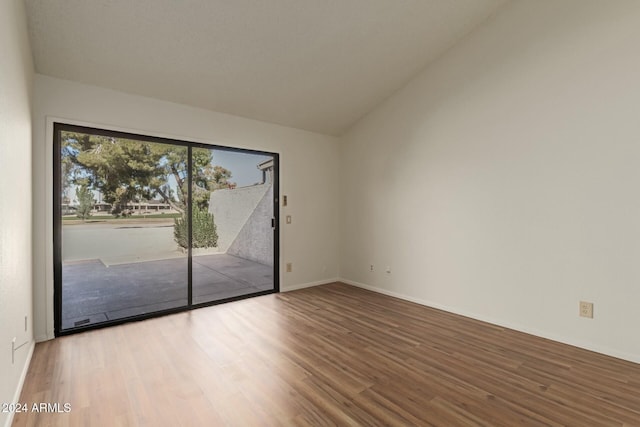 unfurnished room with wood-type flooring and lofted ceiling