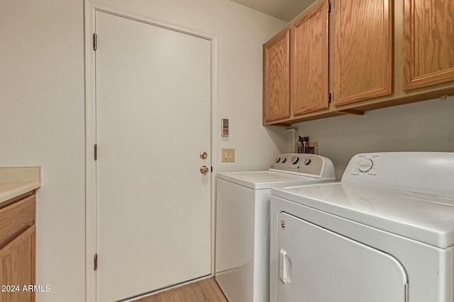 washroom featuring cabinets, washer and dryer, and light hardwood / wood-style floors