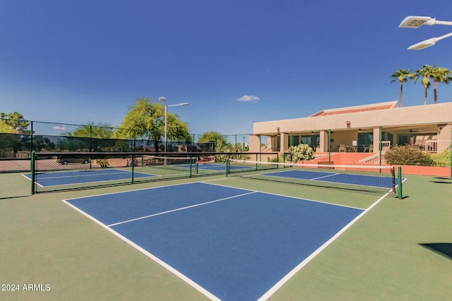 view of tennis court with basketball hoop