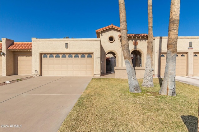 view of front of property featuring a garage and a front lawn