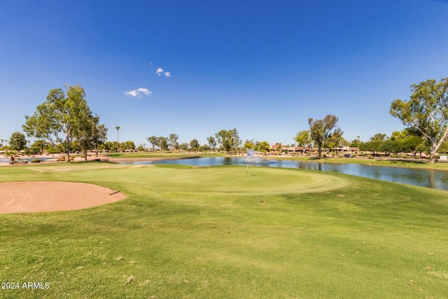 surrounding community with a water view and a yard