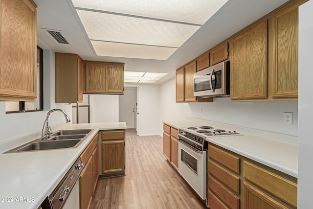 kitchen with stainless steel appliances, sink, and light wood-type flooring