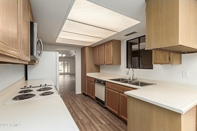 kitchen with sink, stovetop, dark hardwood / wood-style floors, white dishwasher, and a chandelier