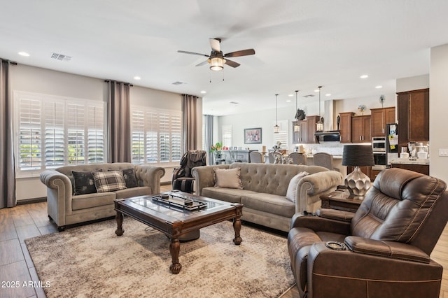 living room with recessed lighting, plenty of natural light, visible vents, and a ceiling fan