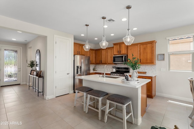21090 N 267th Dr, Buckeye, AZ 85396 - kitchen with appliances with stainless steel finishes, a sink, brown cabinetry, backsplash, and visible vents