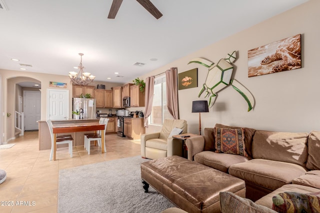living area with recessed lighting, light tile patterned floors, ceiling fan with notable chandelier, arched walkways, and visible vents