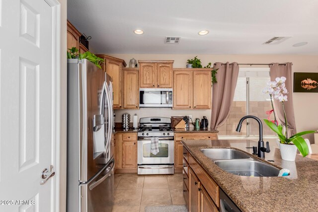 kitchen with light tile patterned floors, a sink, stainless steel appliances, and visible vents