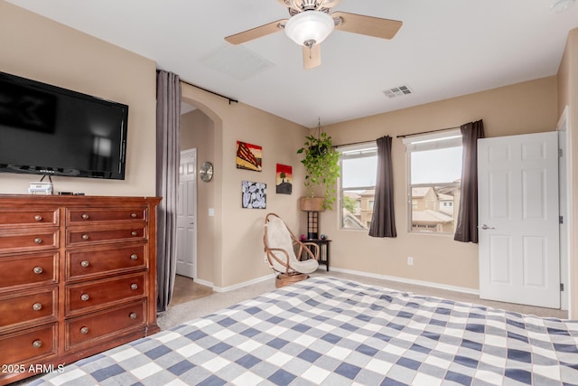 bedroom featuring visible vents, baseboards, a ceiling fan, light carpet, and arched walkways