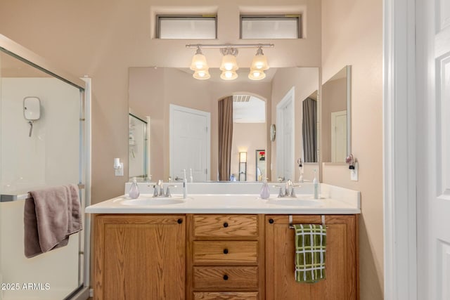 full bathroom with double vanity, a sink, and a shower stall