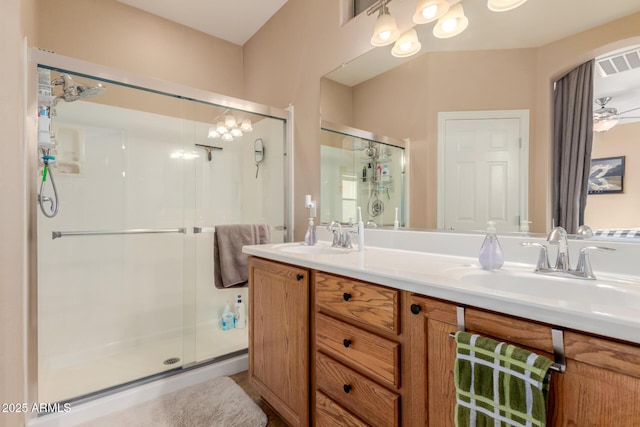full bath featuring visible vents, a sink, a stall shower, and double vanity