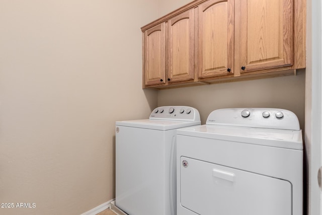 washroom featuring baseboards, cabinet space, and washer and dryer