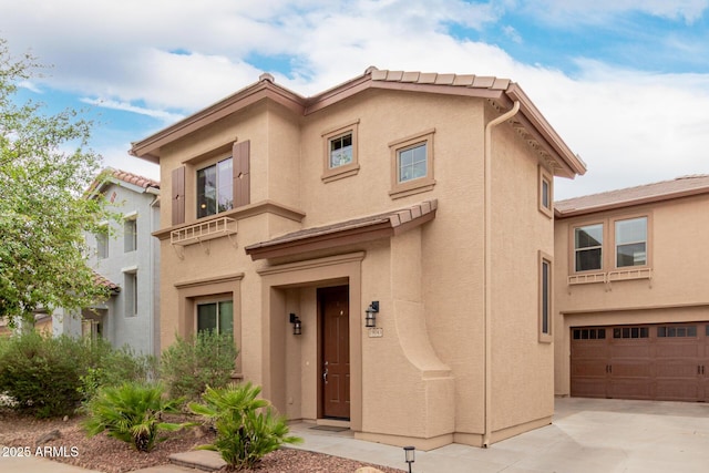 mediterranean / spanish-style home featuring stucco siding, driveway, and a garage