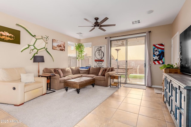 living room featuring visible vents, light tile patterned flooring, and ceiling fan