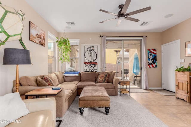 living room featuring light tile patterned floors, baseboards, a healthy amount of sunlight, and a ceiling fan