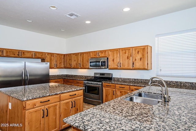 kitchen with visible vents, a sink, brown cabinetry, and appliances with stainless steel finishes