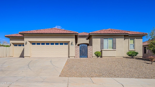 mediterranean / spanish home with a tiled roof, stucco siding, driveway, and a garage