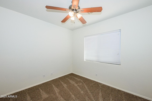spare room featuring baseboards, a ceiling fan, and dark colored carpet