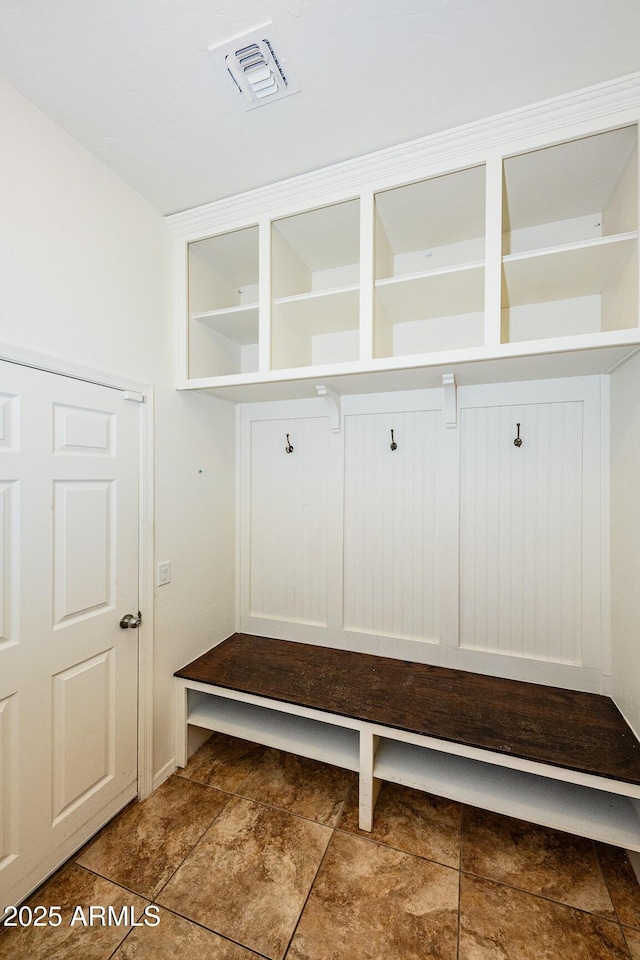 mudroom featuring stone finish floor and visible vents