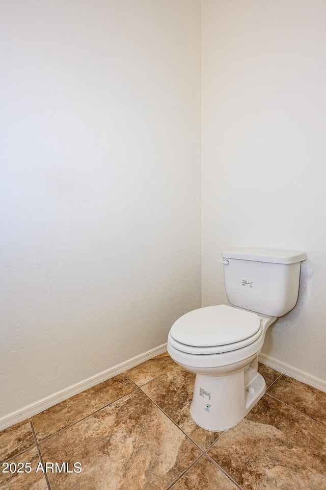 bathroom with baseboards and toilet