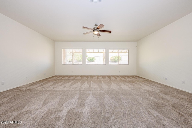 carpeted spare room with visible vents and a ceiling fan