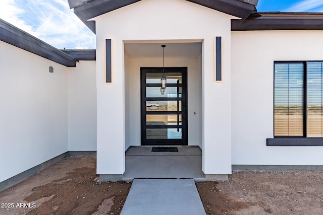 entrance to property featuring stucco siding