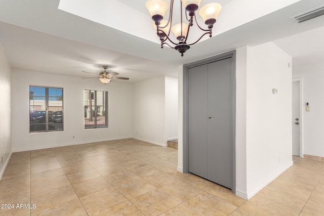 unfurnished room featuring light tile patterned floors and ceiling fan with notable chandelier