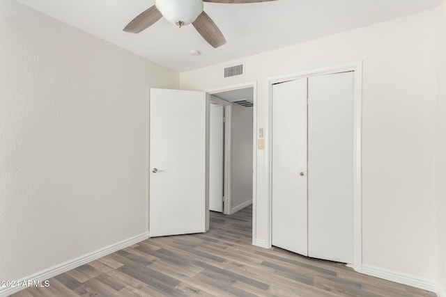 unfurnished bedroom featuring ceiling fan, a closet, and light hardwood / wood-style floors