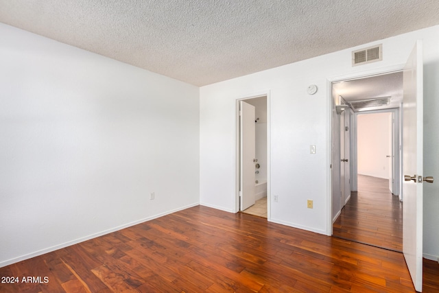 unfurnished room featuring dark hardwood / wood-style floors and a textured ceiling