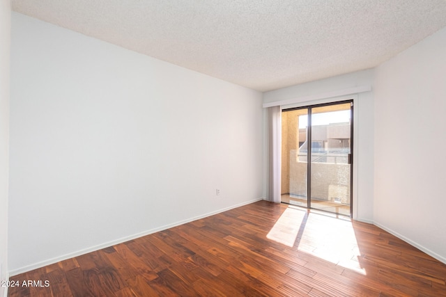 unfurnished room featuring dark hardwood / wood-style floors and a textured ceiling