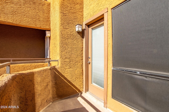 view of exterior entry with a balcony