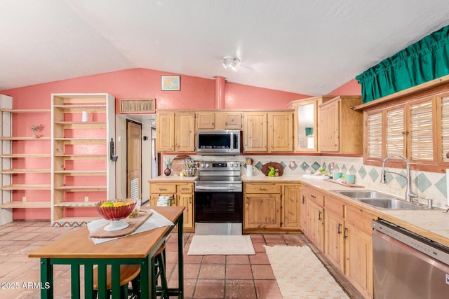 kitchen featuring appliances with stainless steel finishes, light countertops, a sink, and light brown cabinets