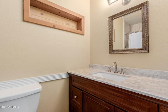 full bath featuring vanity and toilet