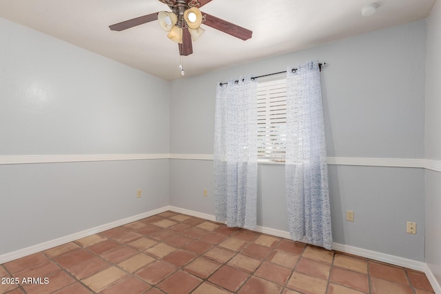 empty room featuring ceiling fan and baseboards