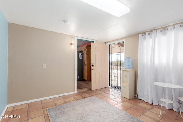 empty room featuring light tile patterned floors and baseboards