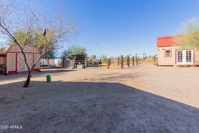 view of yard featuring an outbuilding, fence, and a storage shed