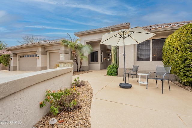 view of front facade featuring stucco siding, an attached garage, and a tiled roof