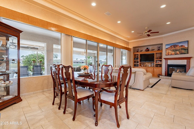 dining room featuring ornamental molding, a ceiling fan, built in features, recessed lighting, and a fireplace