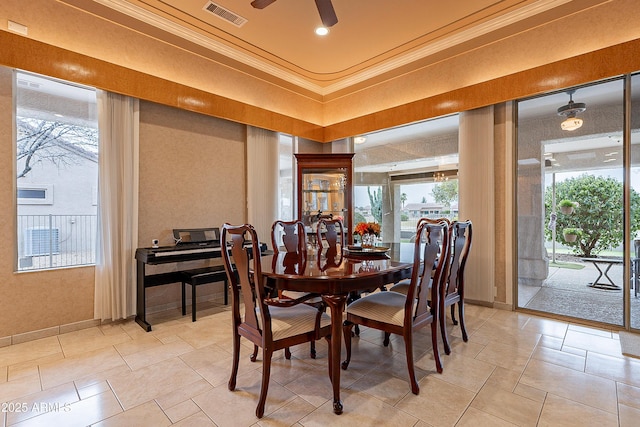 dining space featuring a ceiling fan, baseboards, visible vents, and ornamental molding